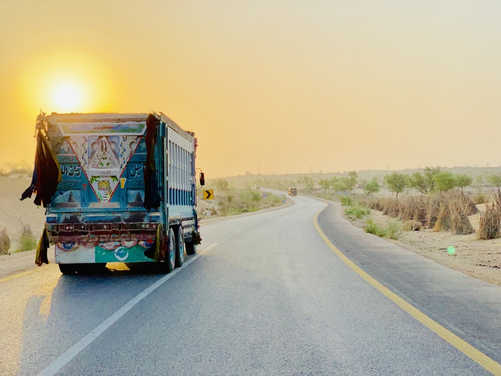 white and blue truck on gray pavement road