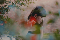 A serene outdoor portrait of a model surrounded by soft natural light and greenery.