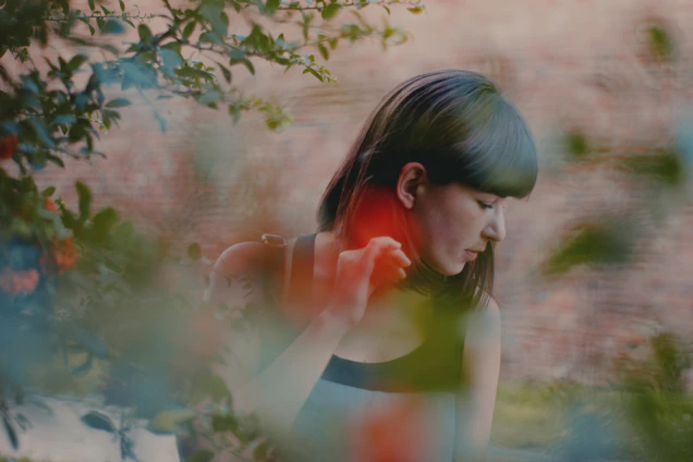 A serene portrait of Ester Águila surrounded by soft natural light and gentle greenery.