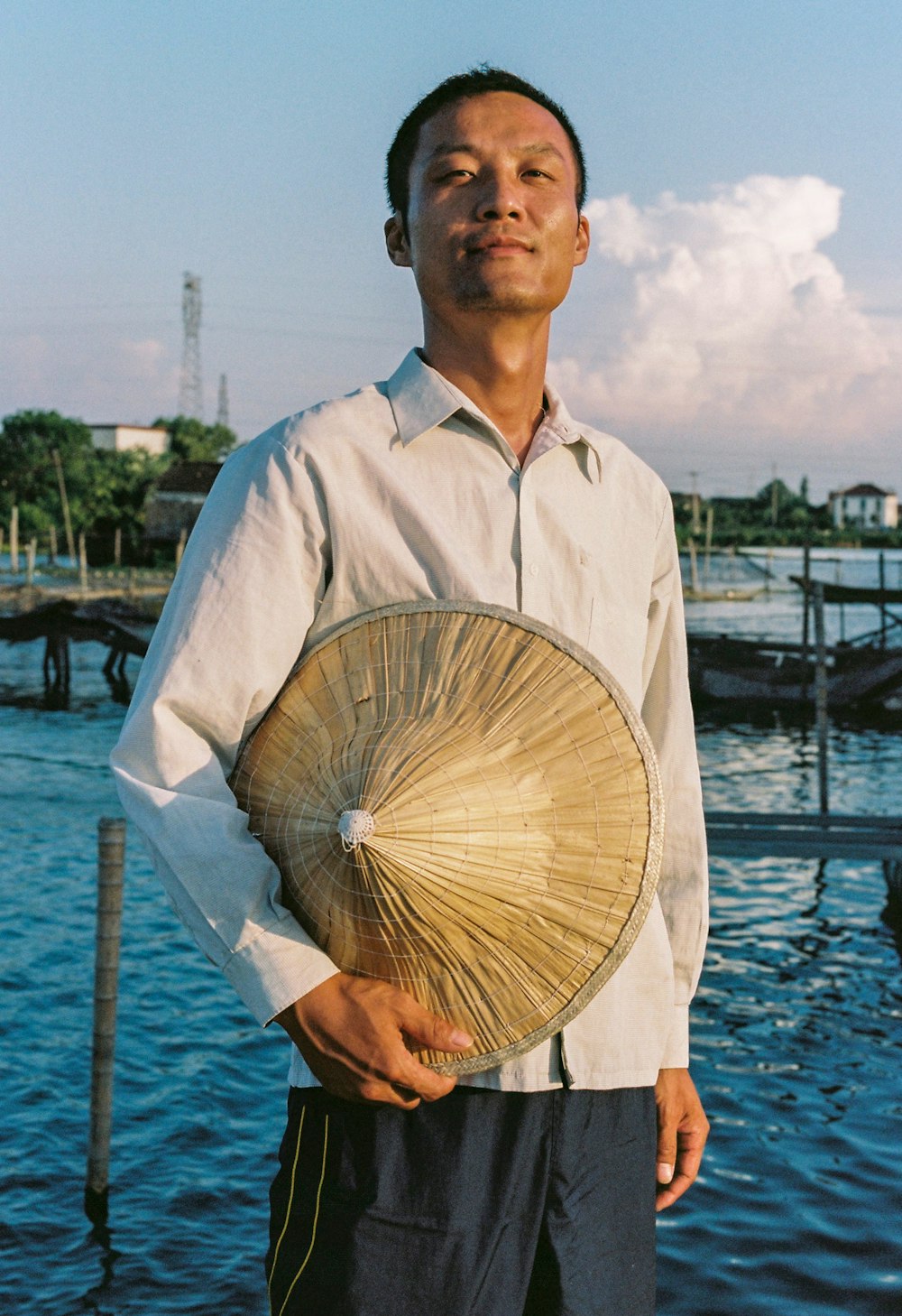 standing man wearing gray shirt holding brown hat