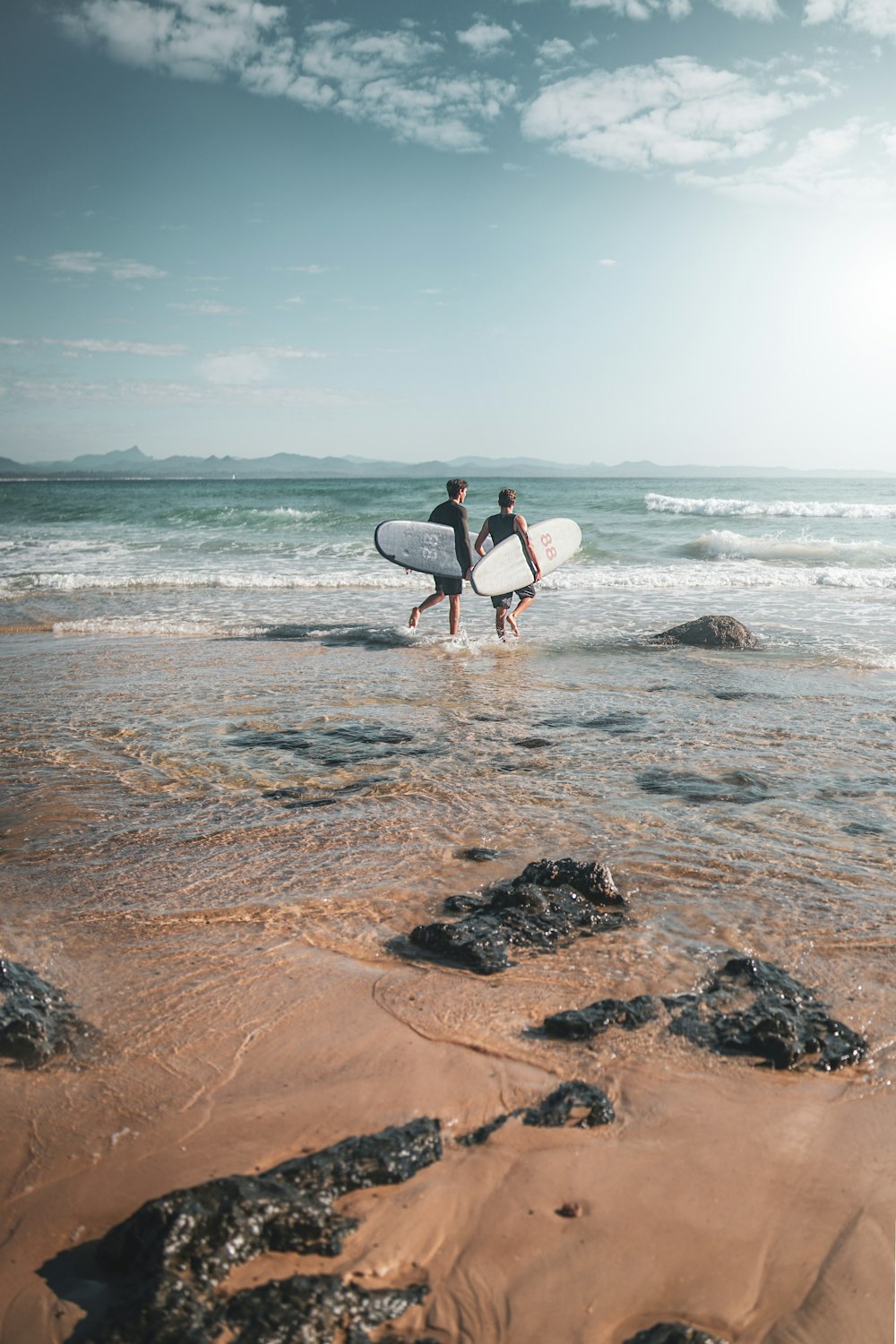 two person walking on shore