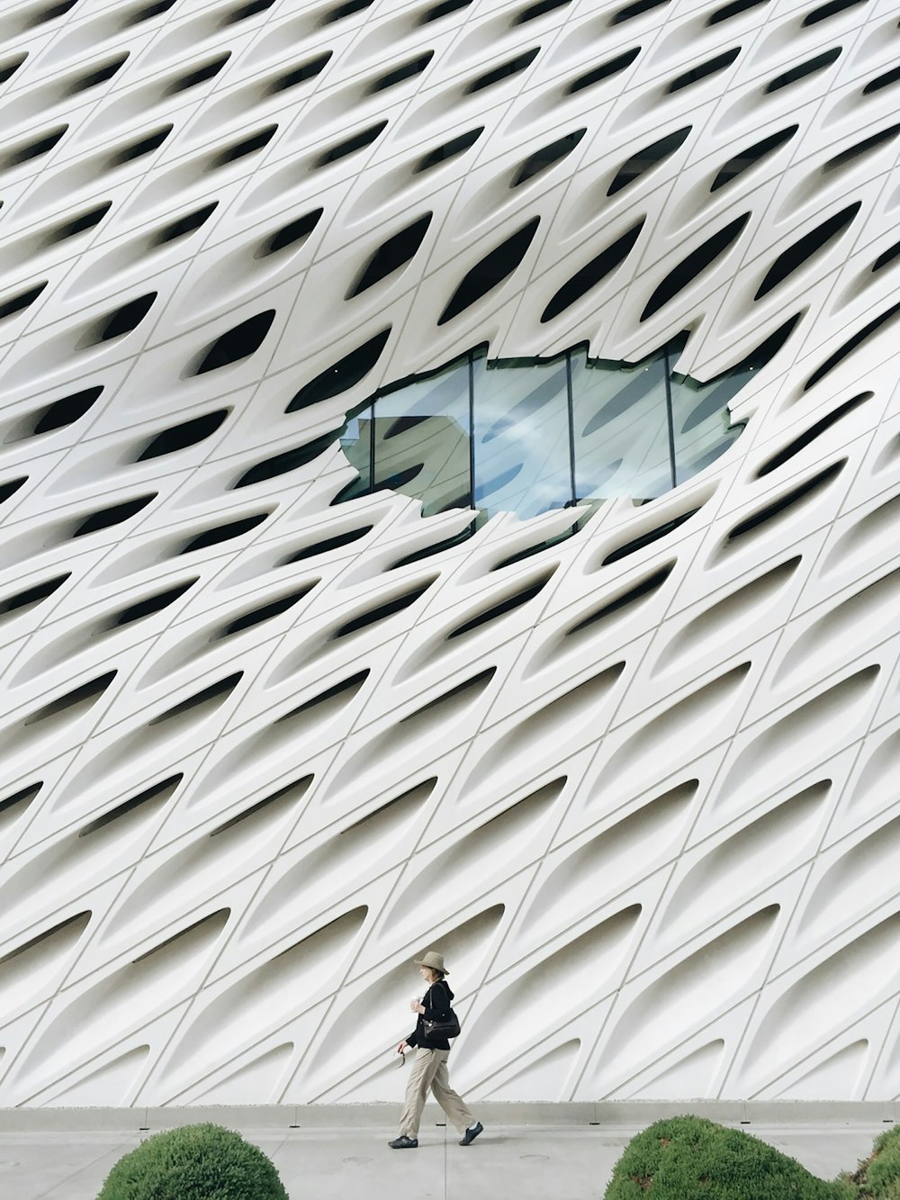 person walking beside white building