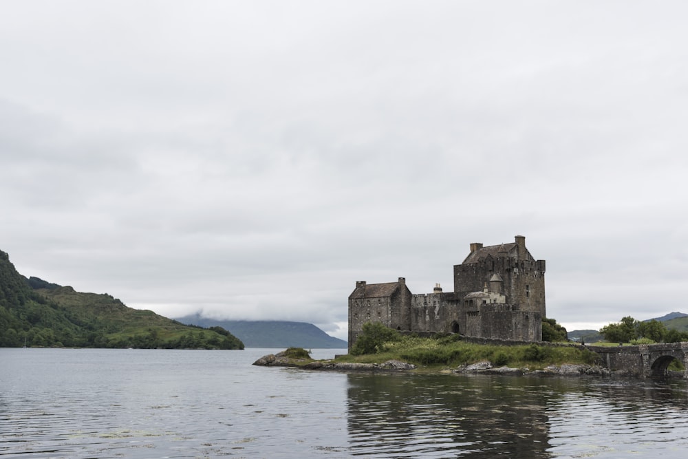 brown brick castle surrounded with body of water