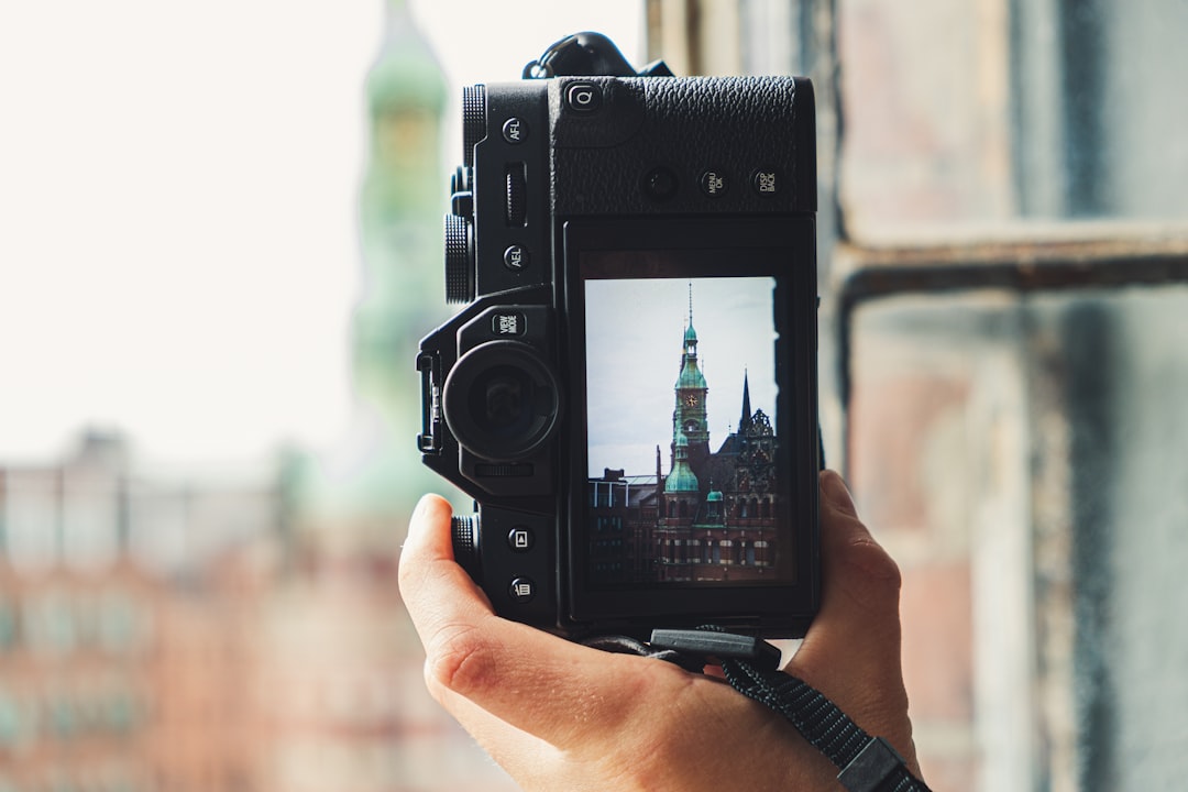 person holding camera with tower photo