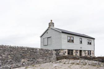 A sturdy house with a protective shield overlay representing property insurance