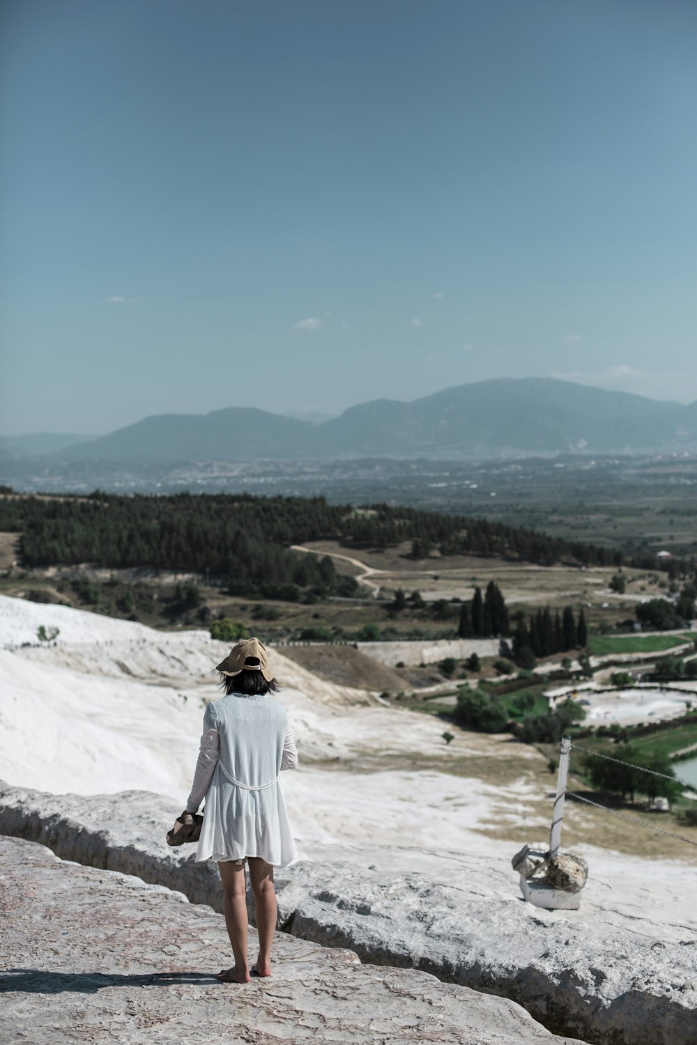 woman walking near trees and mountain at daytime