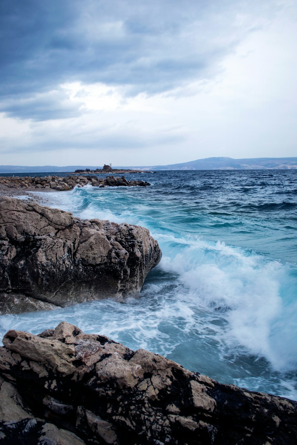 a large body of water next to a rocky shore