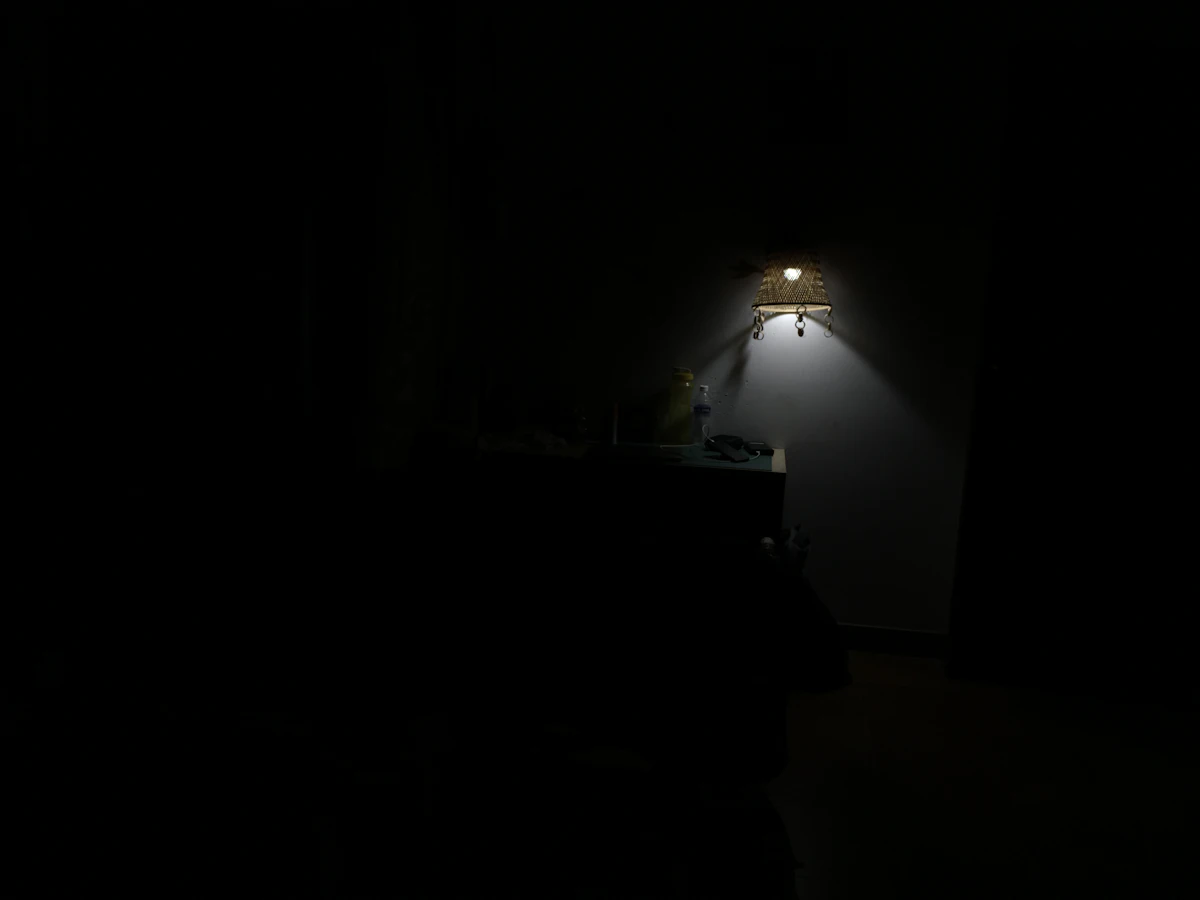 Ruangan gelap dengan satu lampu menyala di dinding
