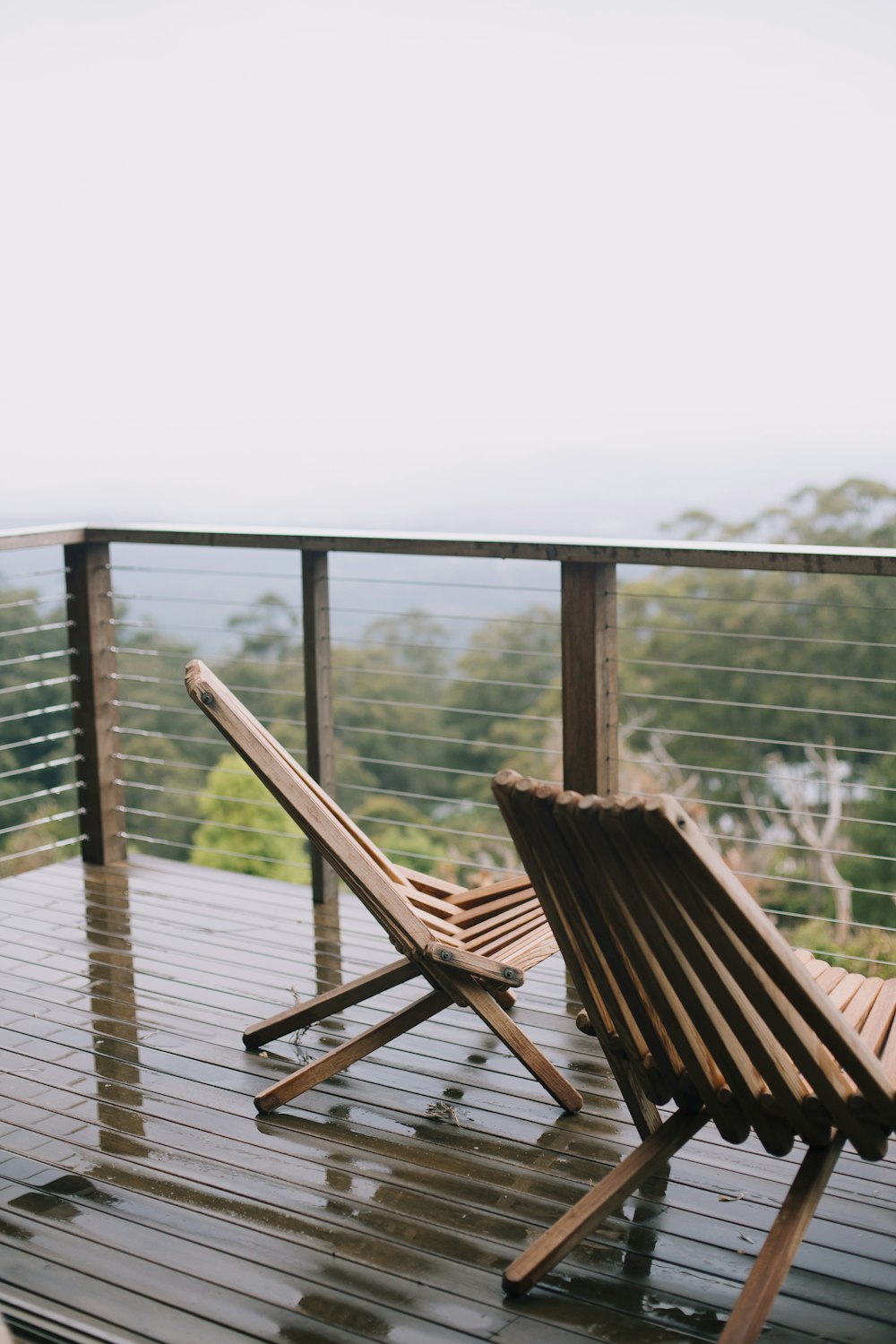 two brown wooden folding lounge chairs at the balcony