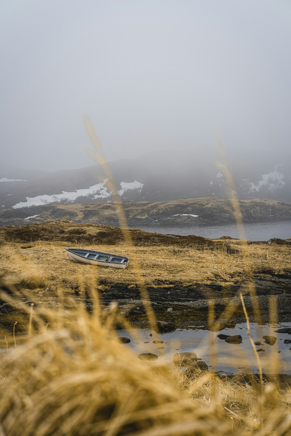 graues Boot auf getrocknetem Gras