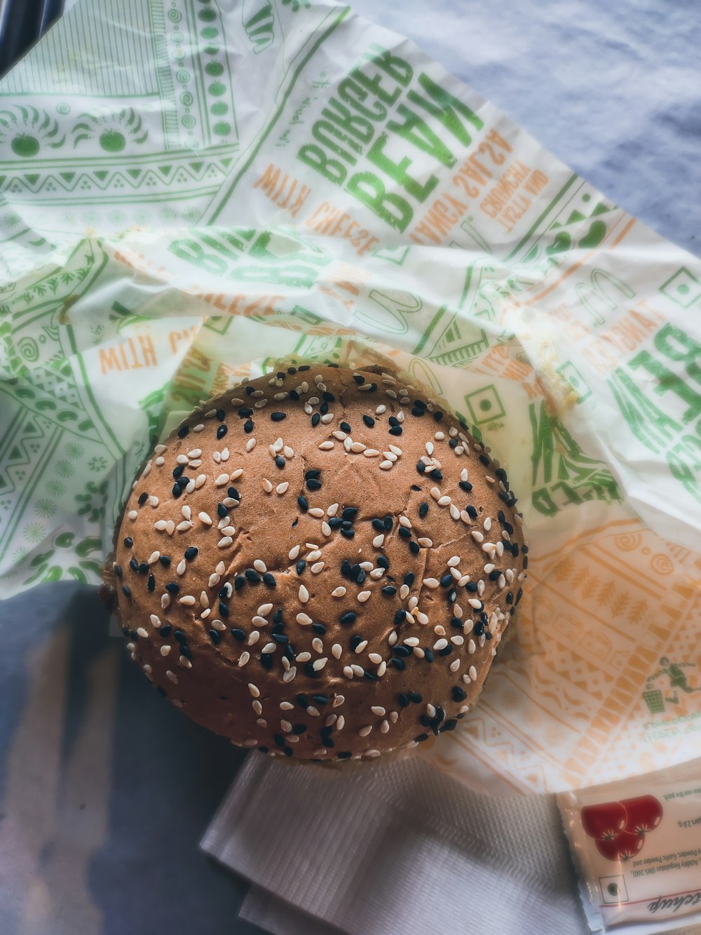 a bagel with sesame seeds on it sitting on a napkin