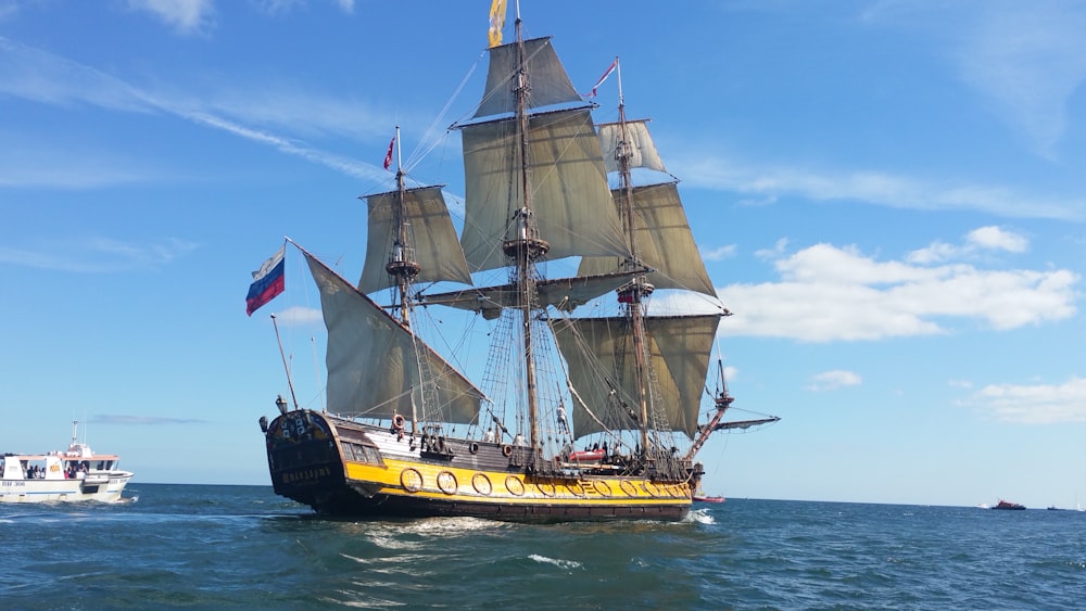 brown and yellow ship on body of water during daytime