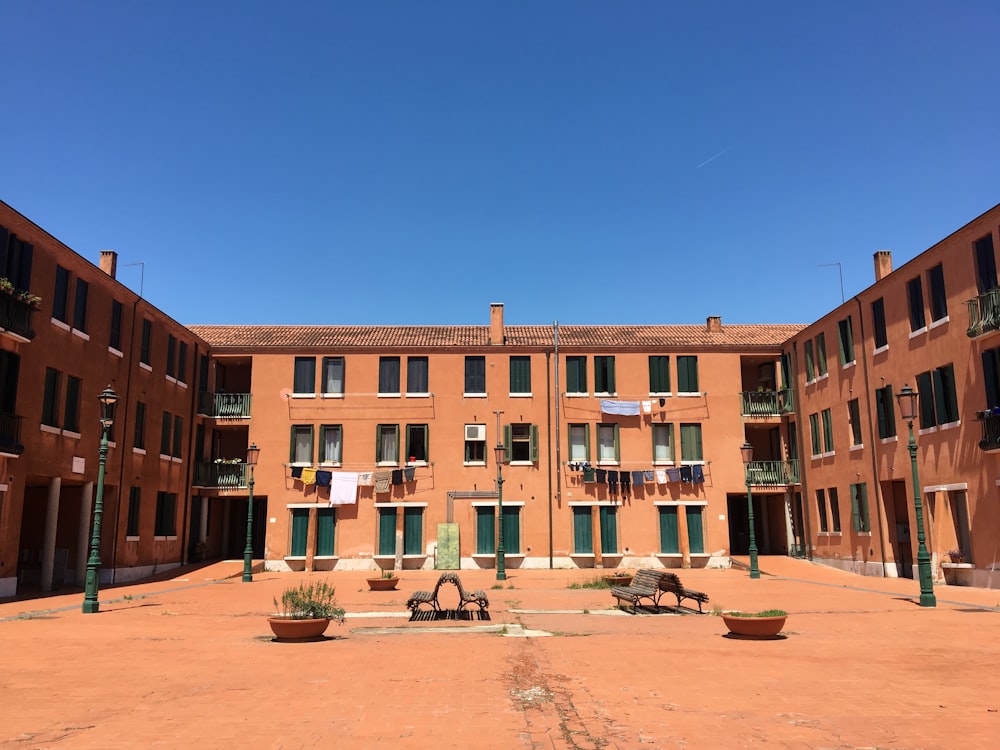 empty benches in front of brown concrete building during daytime