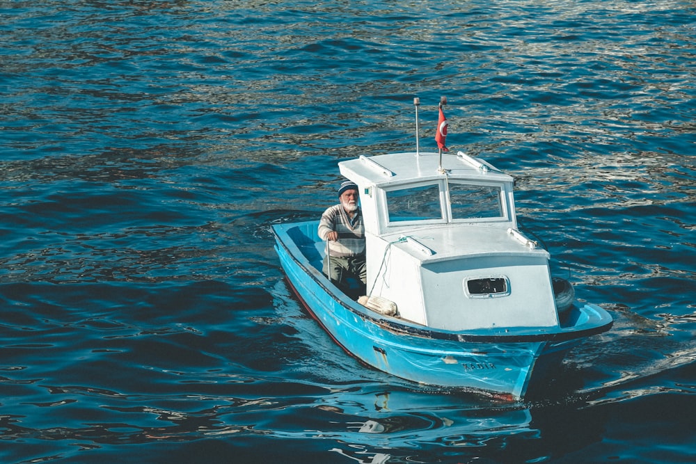 hombre en barco blanco y negro en el mar