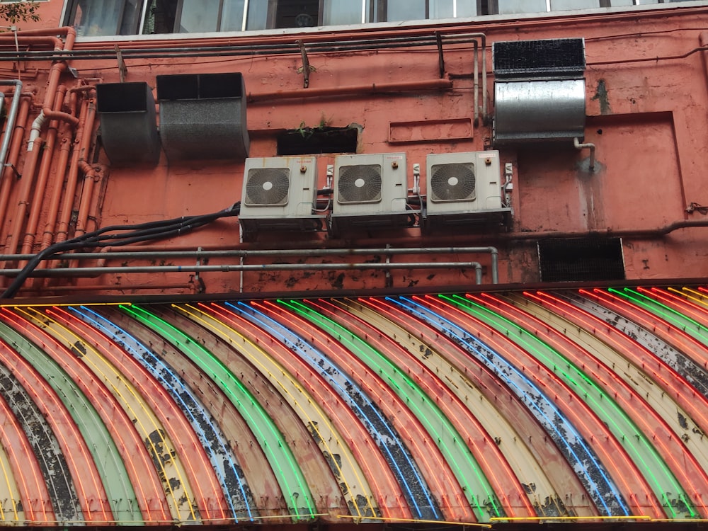 three white AC condenser units on wall