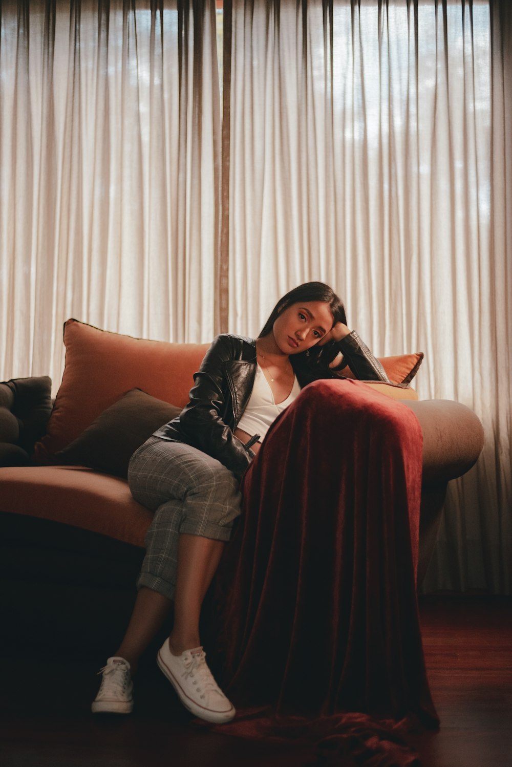 woman sitting with crossed legs on gray couch