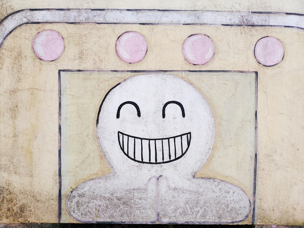 Un disegno di un volto sorridente su un muro