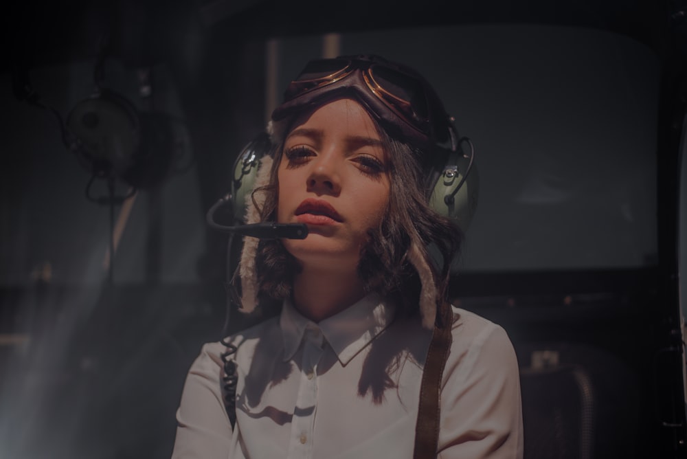 woman wearing white collared button-up long-sleeved shirt using green headphones