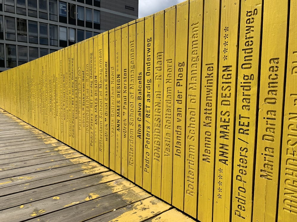 a row of yellow signs sitting next to a tall building