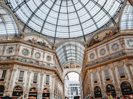 The ornate glass dome and bustling luxury shops inside Galleria Vittorio Emanuele II.