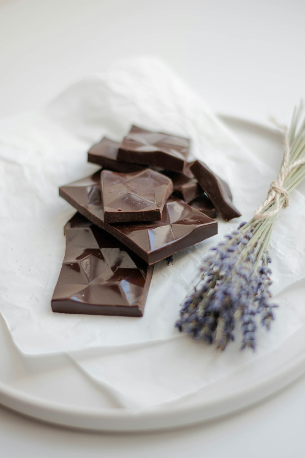 chocolate bars beside flower on white tray