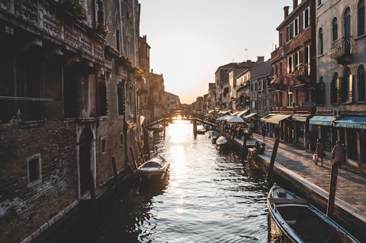 group of people walking on street beside canal