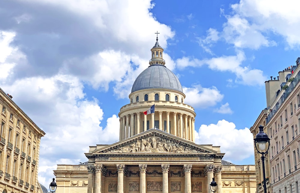 white and gray dome concrete building with flag during daytime