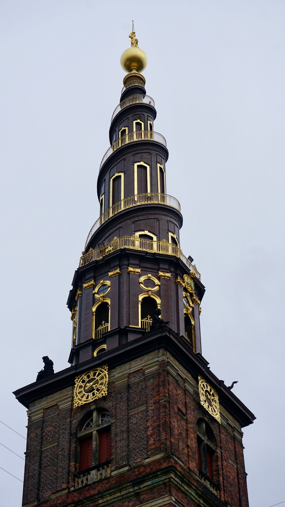 low-angle photography of black concrete tower with spiral stairs