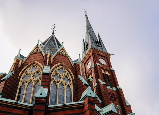 low-angle photography of brown and gray concrete building with towers in Oscar Fredrik Church Sweden