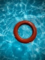 round red swim ring on body of water