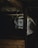 A dimly lit, dusty attic space with cobwebs hanging from the wooden beams and a window letting in a small amount of light.