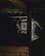 A dimly lit, dusty attic space with cobwebs hanging from the wooden beams and a window letting in a small amount of light.