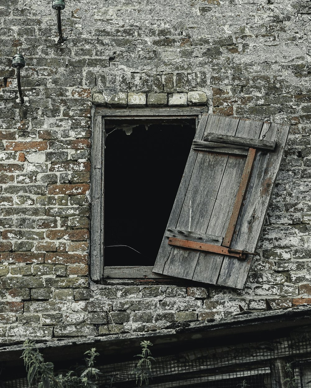 gray stone building showing open grey wooden window