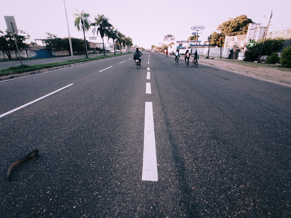 people riding bicycle on road during daytime