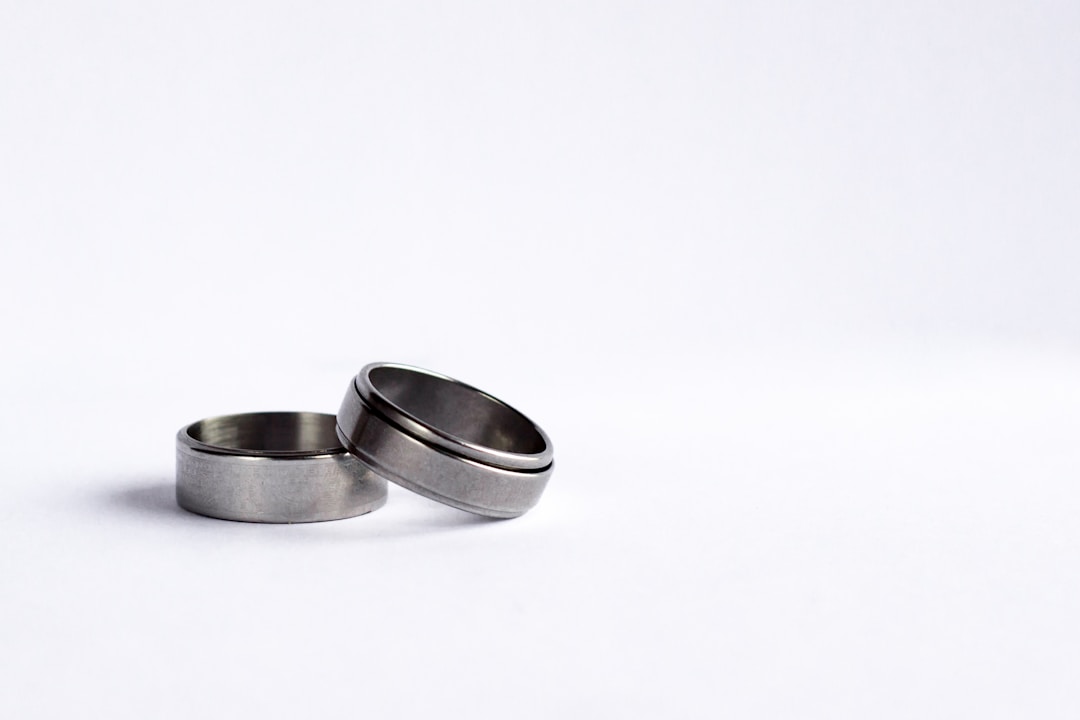 Two wide brushed-silver tungsten wedding bands on a clean white background, representative of stone inlay ring construction
