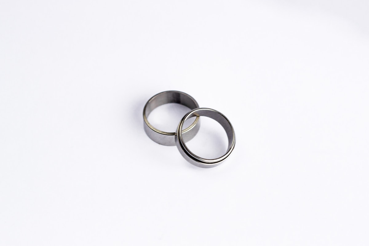 two plain silver-tone men's silver wedding bands on a white background
