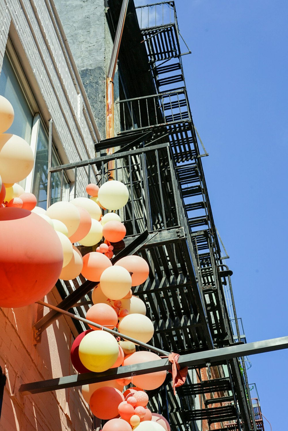 a bunch of balloons hanging from a building