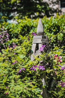 A beautifully crafted wooden garden decoration surrounded by flowers.