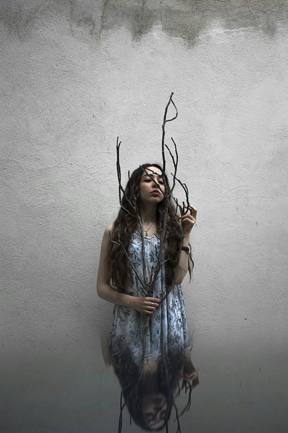 woman holding leafless branch