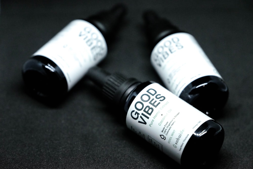 shallow focus photo of three black glass bottles