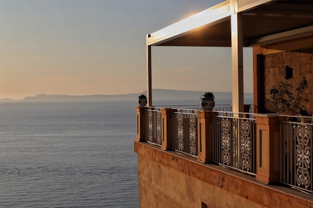 Happy family enjoying a sunny day on a balcony with Nerja's cliffs in the background.