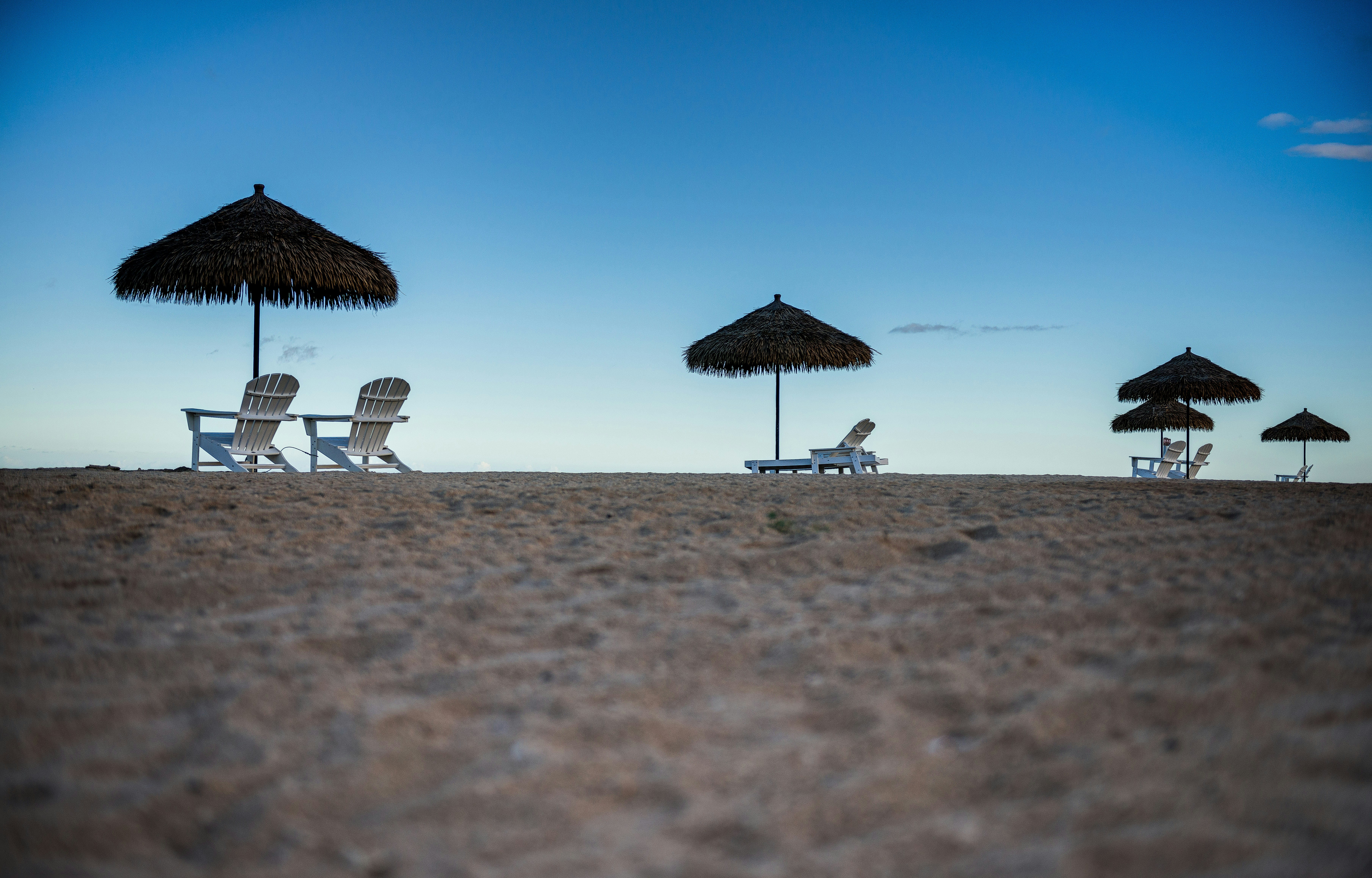 a beach with chairs and umbrellas on the sand, Secluded oasis</p><p>