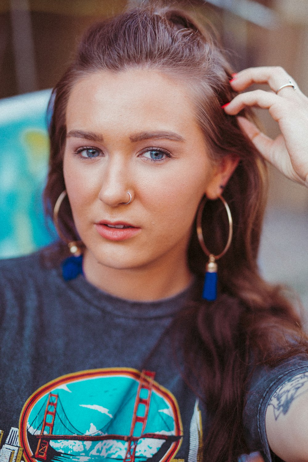 selective focus photography of woman in gray crew-neck shirt touching hair