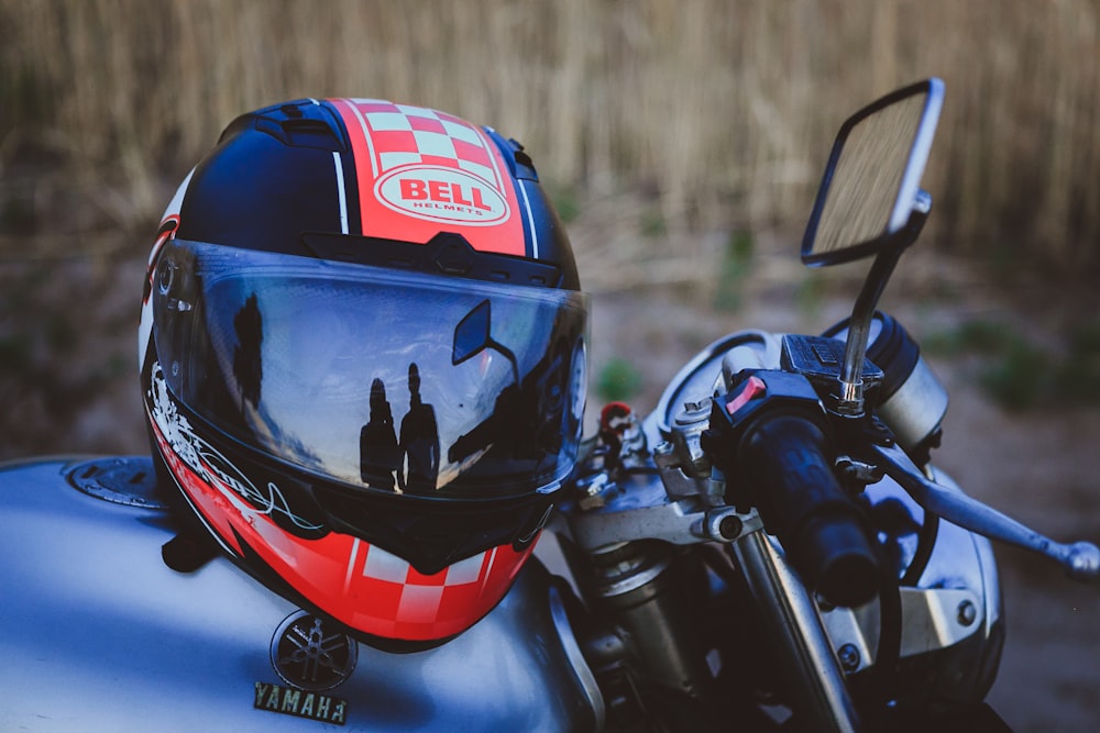 black, red, and white Bell motorcycle helmet on motorcycle