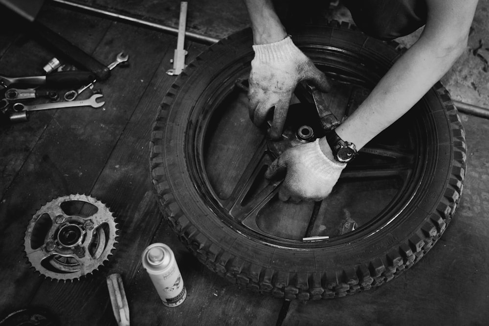 grayscale photography of fixing vehicle wheel