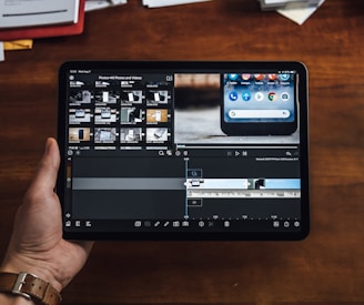 person holding black tablet computer showing video editor