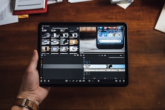 person holding black tablet computer showing video editor