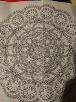 Close-up of a detailed hand-drawn mandala print perfect for coloring.