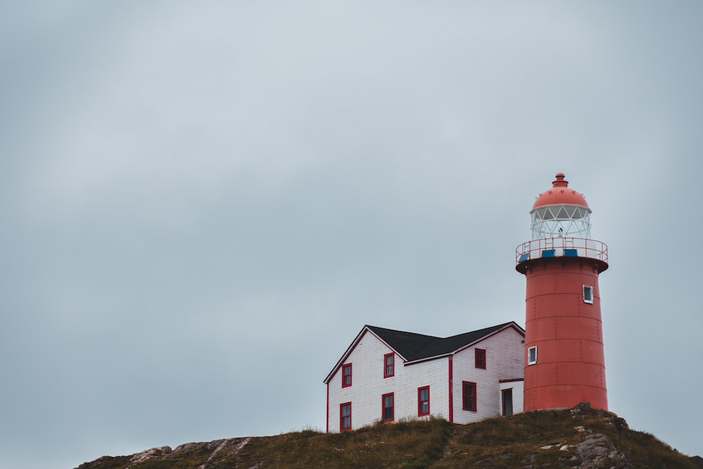 red lighthouse beside house