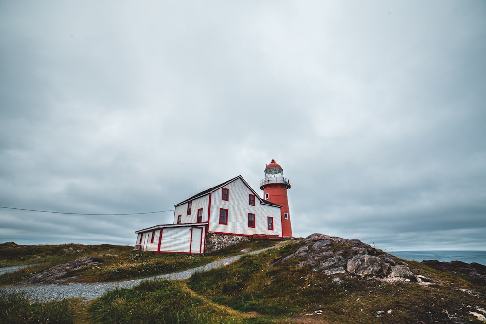 red lighthouse beside white house